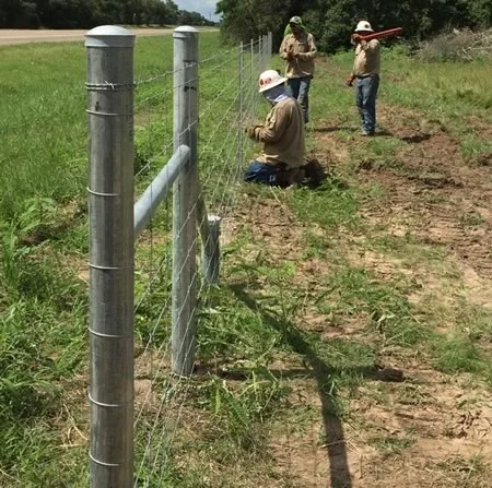 a group of men working on a fence